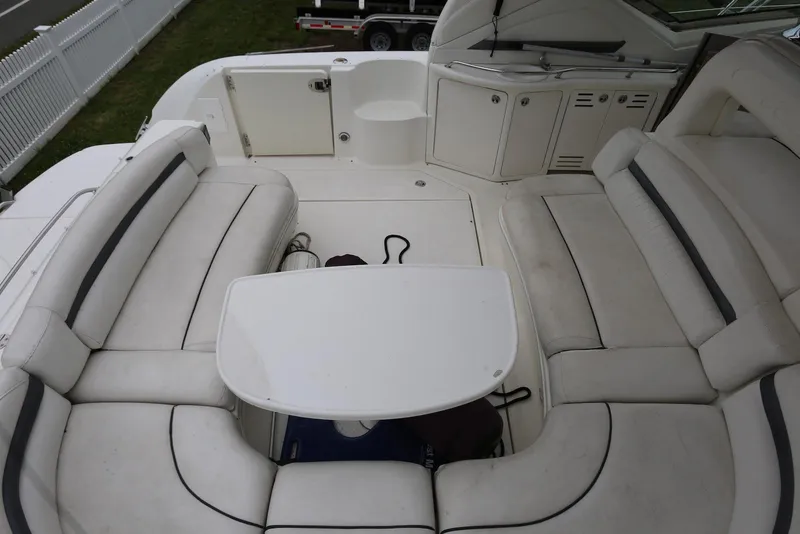 Slide: The Image of 2003 Sea Ray 420 Sundancer cockpit with white seating and table, showcasing luxury boat interior. - 47