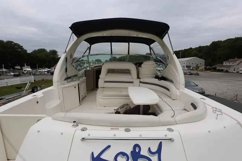 Slide: The Image of 2003 Sea Ray 420 Sundancer yacht with spacious seating and table, docked at marina. - 8