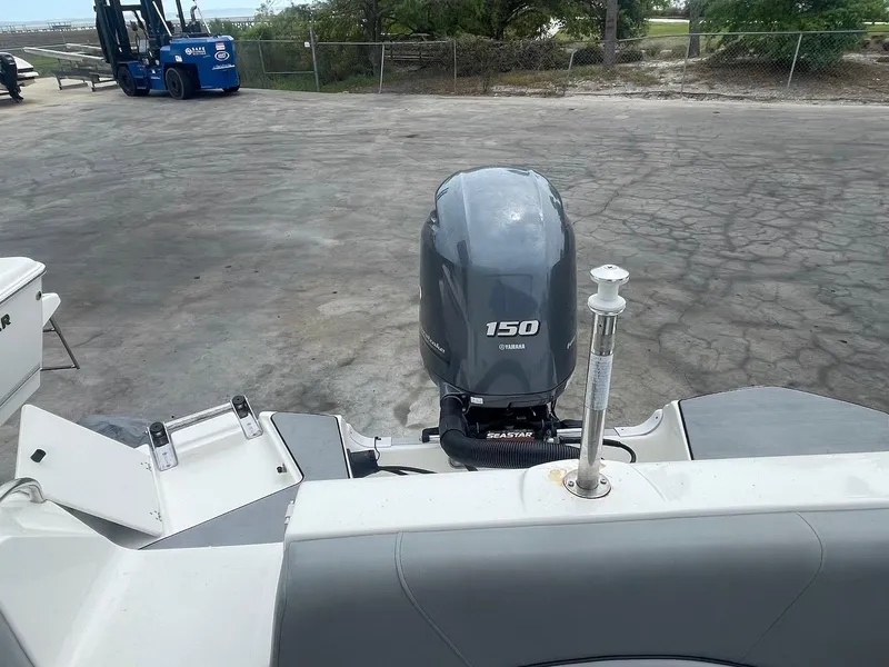 Slide: The Image of 2021 NauticStar 223 DC boat with Yamaha 150 outboard motor in a parking area. - 10