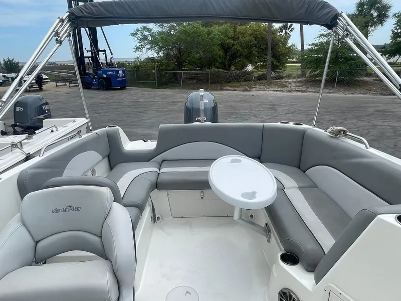 Slide: The Image of 2021 NauticStar 223 DC boat interior with gray seating and round table. - 3