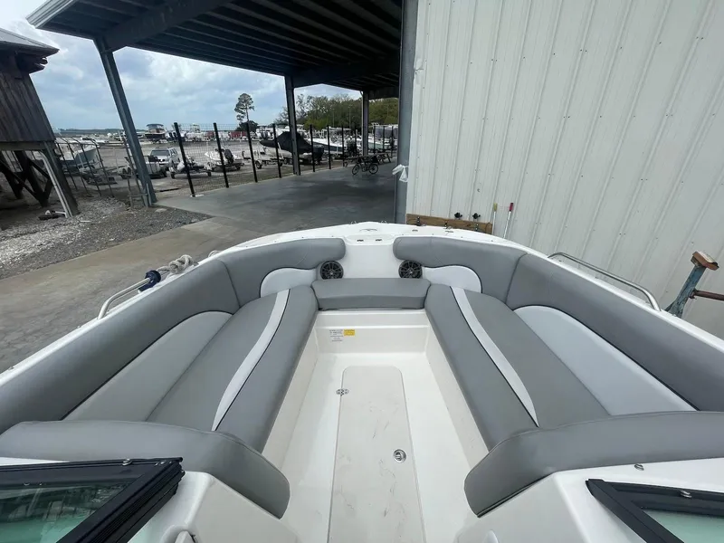 Slide: The Image of 2021 NauticStar 223 DC boat with spacious seating, docked near a marina. - 7