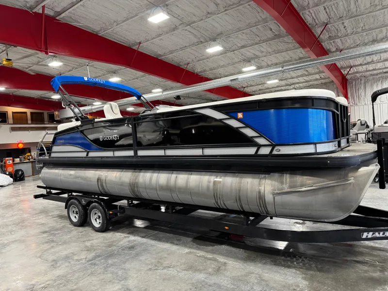 Slide: The Image of 2020 Godfrey 250 Monaco pontoon boat on trailer in indoor storage facility. - 1