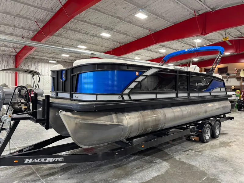 Slide: The Image of 2020 Godfrey 250 Monaco pontoon boat on trailer in indoor storage facility. - 2
