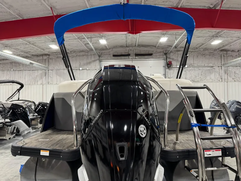 Slide: The Image of 2020 Godfrey 250 Monaco boat with blue canopy and powerful outboard motor in showroom. - 6