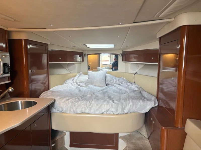 Slide: The Image of 2008 Sea Ray 330 Sundancer cabin interior with bed, wood cabinets, and sink. - 15