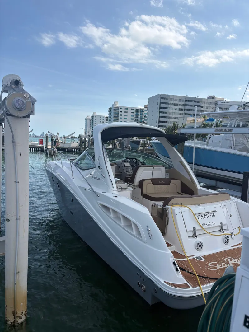 Slide: The Image of 2008 Sea Ray 330 Sundancer docked at marina with cityscape background. - 3