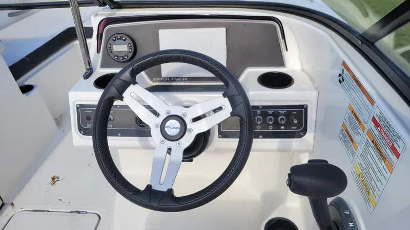 Slide: The Image of 2021 Bayliner DX 2200 boat dashboard with steering wheel and control panel. - 7