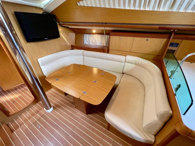Slide: The Image of Interior of 2008 Jeanneau Sun Odyssey 42 DS with cozy seating and wooden table. - 17