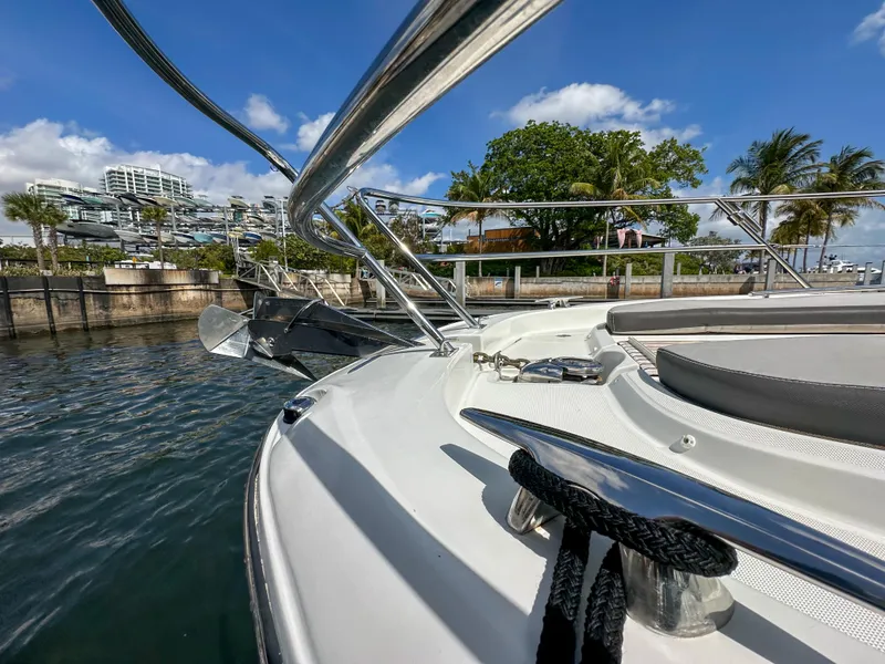 Slide: The Image of 2021 Jeanneau Leader 10.5 WA boat docked by waterfront, sunny day, palm trees in background. - 16