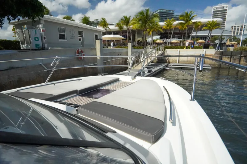 Slide: The Image of 2021 Jeanneau Leader 10.5 WA boat docked near palm trees and modern buildings. - 23
