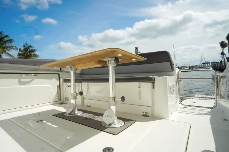 Slide: The Image of 2021 Jeanneau Leader 10.5 WA boat deck with seating and table, docked by the water. - 25