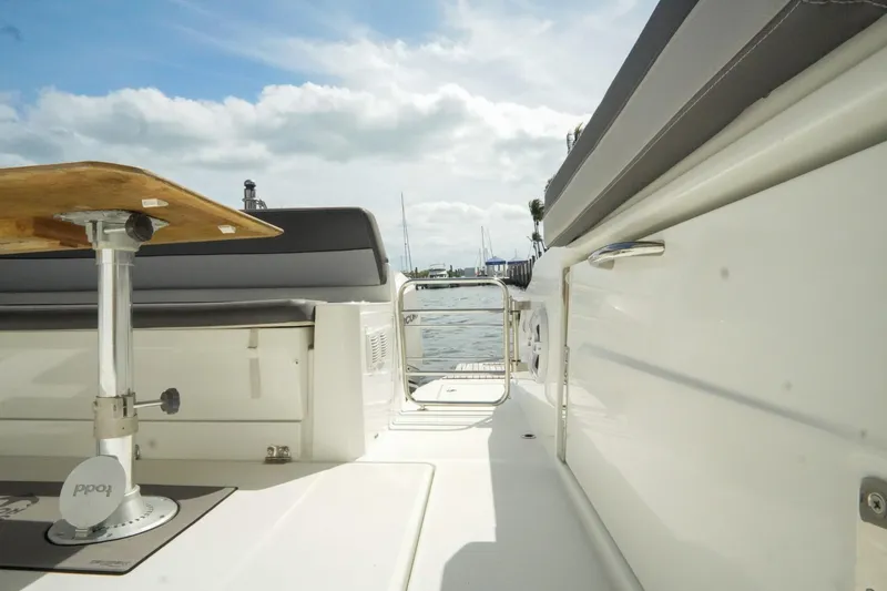 Slide: The Image of 2021 Jeanneau Leader 10.5 WA boat deck with seating and table, overlooking water. - 26