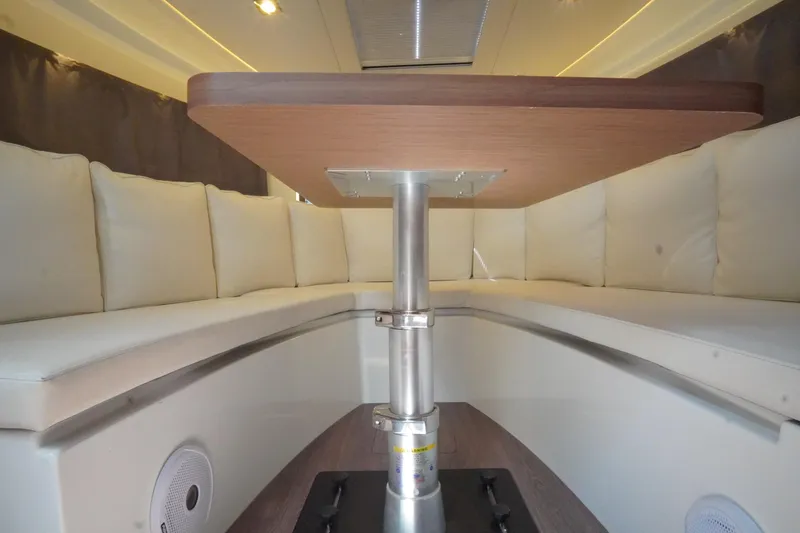 Slide: The Image of Interior of 2021 Jeanneau Leader 10.5 WA boat with cushioned seating and table. - 39