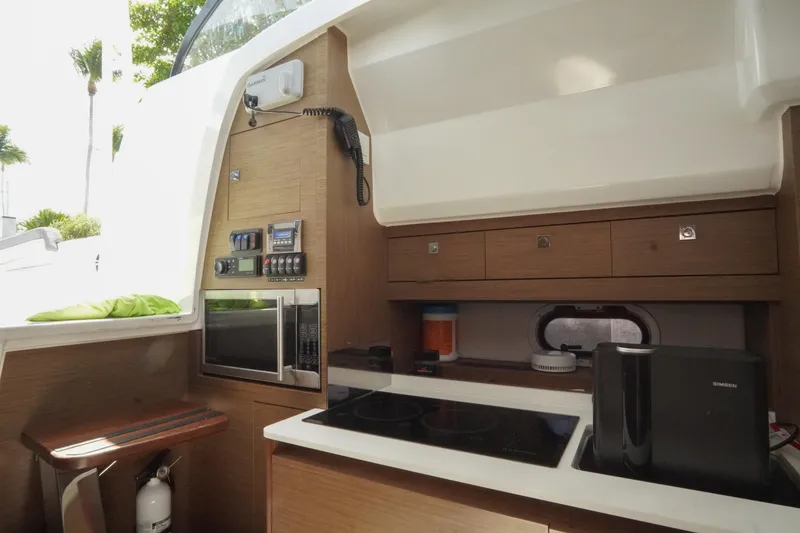 Slide: The Image of 2021 Jeanneau Leader 10.5 WA boat interior kitchen with modern appliances and wooden cabinetry. - 41