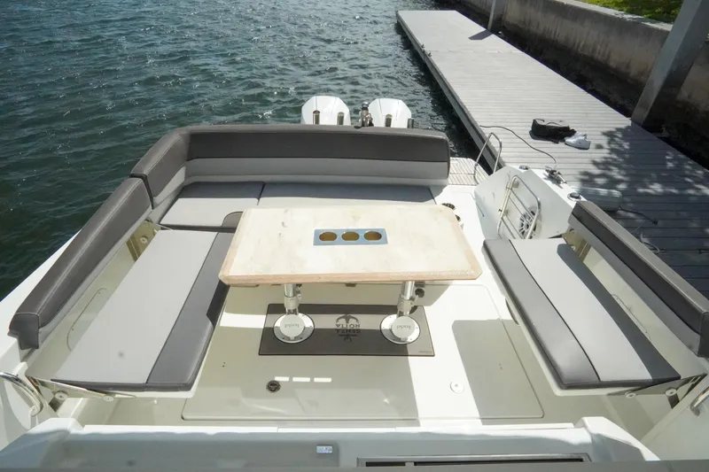 Slide: The Image of 2021 Jeanneau Leader 10.5 WA boat with spacious seating and table, docked by the water. - 45
