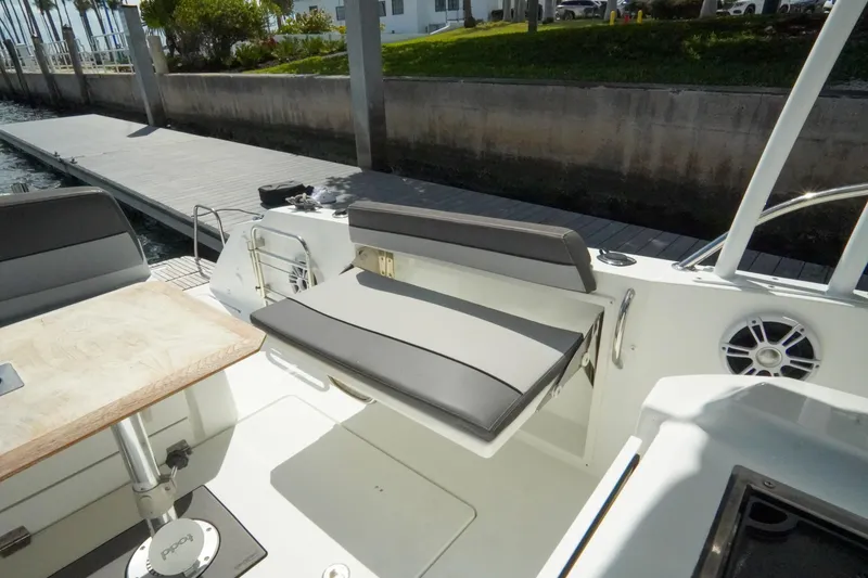 Slide: The Image of 2021 Jeanneau Leader 10.5 WA boat interior with seating and table near dock. - 47