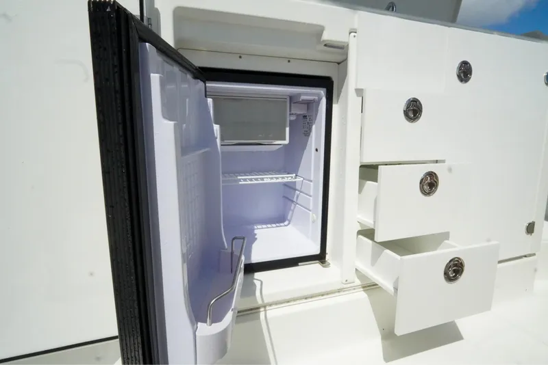 Slide: The Image of 2021 Jeanneau Leader 10.5 WA boat interior with open fridge and storage drawers. - 49