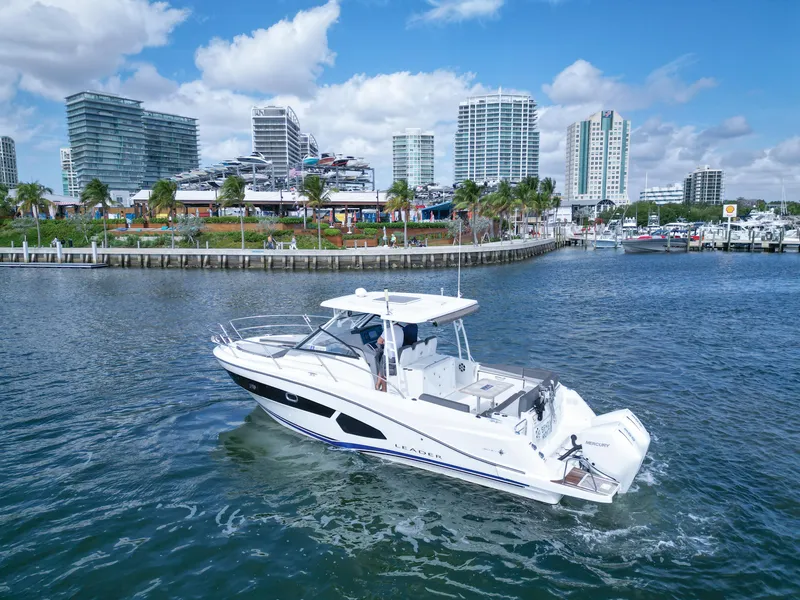 Slide: The Image of 2021 Jeanneau Leader 10.5 WA boat cruising near urban waterfront skyline. - 9