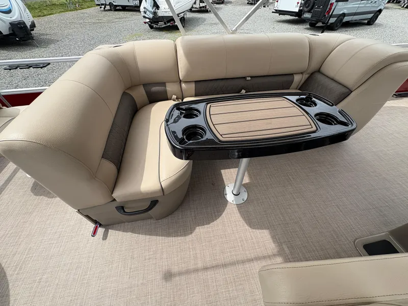 Slide: The Image of 2021 Sun Tracker Fishin' Barge 20 DLX interior with beige seating and a central table. - 11