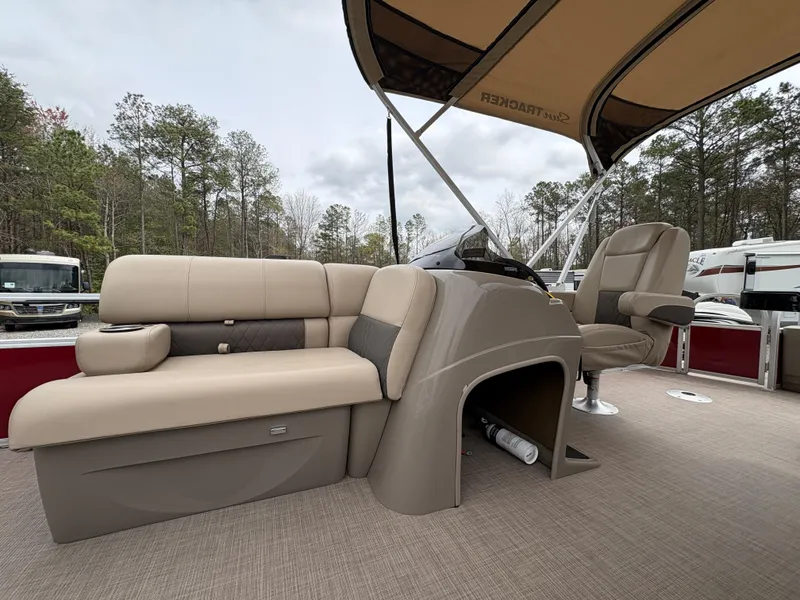 Slide: The Image of 2021 Sun Tracker Fishin' Barge 20 DLX interior with seating and canopy in wooded area. - 15