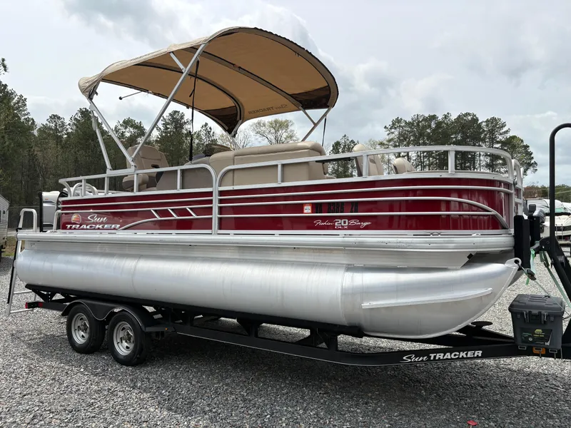 Slide: The Image of 2021 Sun Tracker Fishin' Barge 20 DLX pontoon boat on trailer, parked outdoors. - 6