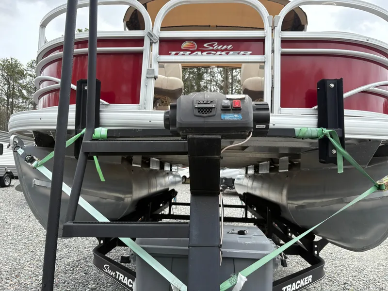 Slide: The Image of 2021 Sun Tracker Fishin' Barge 20 DLX pontoon boat on trailer, front view. - 7