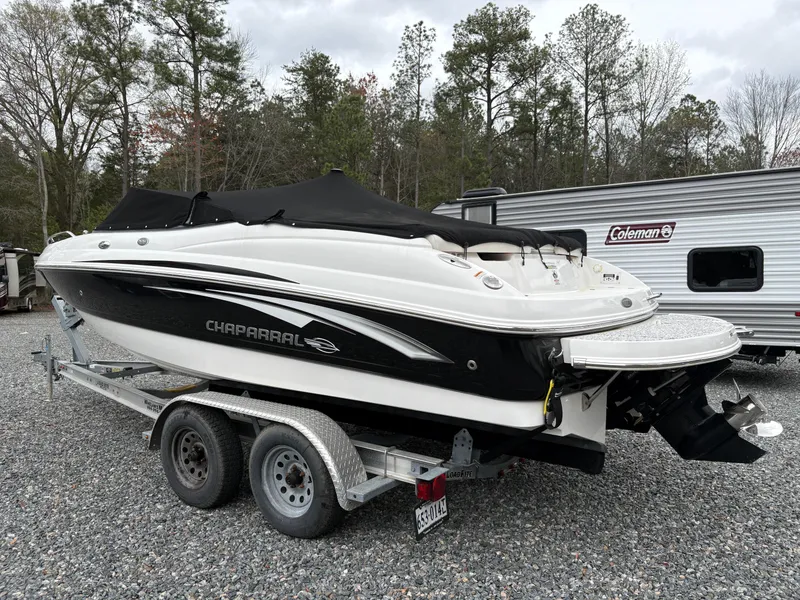 Slide: The Image of 2009 Chaparral 210 SSi boat on trailer, parked outdoors near trees and a camper. - 1