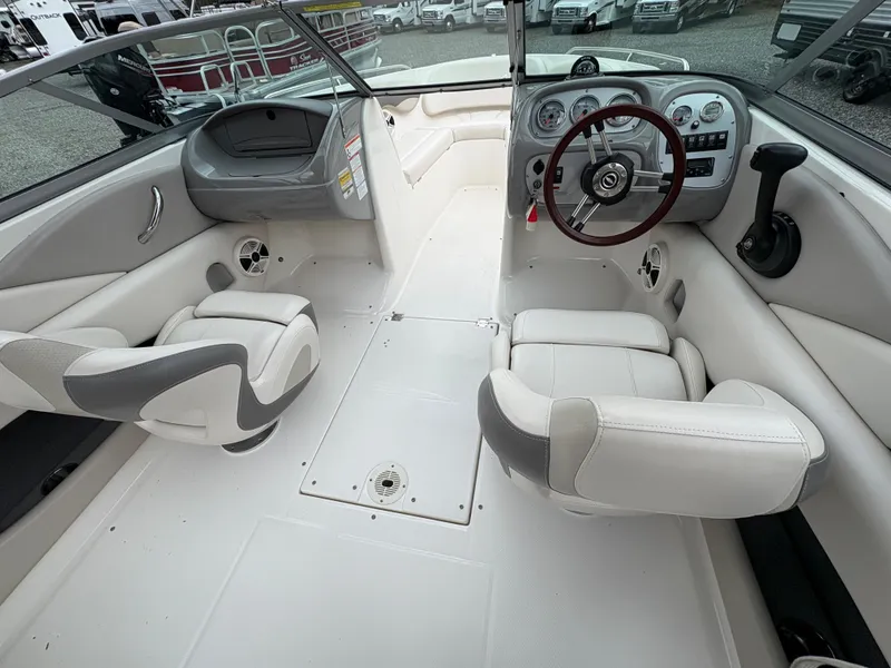 Slide: The Image of 2009 Chaparral 210 SSi boat interior with white seating and modern dashboard. - 13