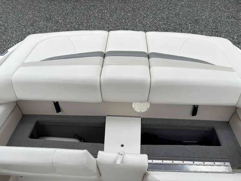 Slide: The Image of 2009 Chaparral 210 SSi boat interior with white cushioned seating and storage compartment. - 27