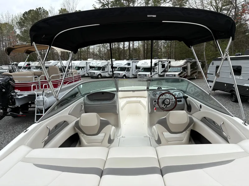 Slide: The Image of 2009 Chaparral 210 SSi boat interior with canopy, parked among RVs and trailers. - 28