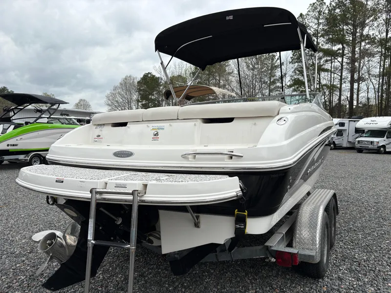 Slide: The Image of 2009 Chaparral 210 SSi boat on trailer, black and white, with canopy, parked outdoors. - 29