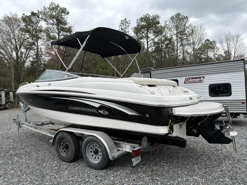 Slide: The Image of 2009 Chaparral 210 SSi boat on trailer, black and white, parked near RV. - 33