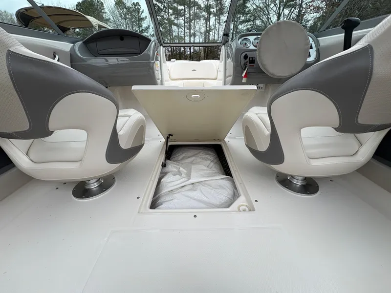 Slide: The Image of 2009 Chaparral 210 SSi boat interior with two swivel seats and storage compartment. - 9