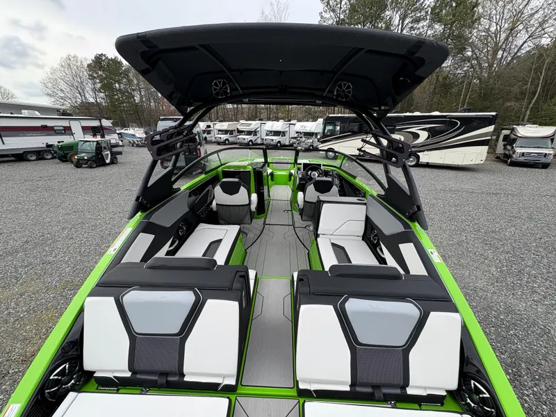 Slide: The Image of 2022 Yamaha Boats 255XD with sleek green and white interior, parked outdoors. - 10