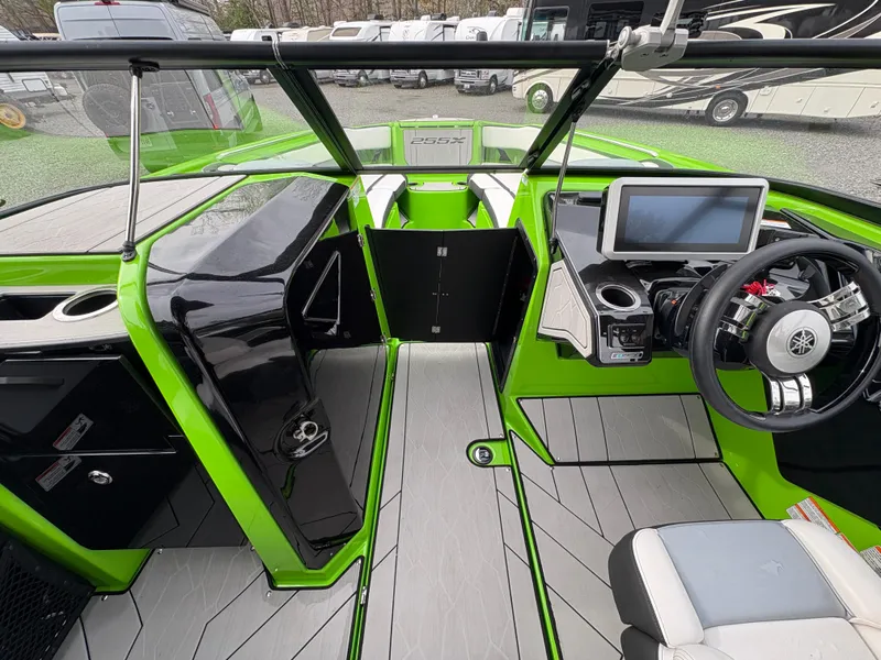 Slide: The Image of 2022 Yamaha Boats 255XD interior with green accents, modern dashboard, and steering wheel. - 27