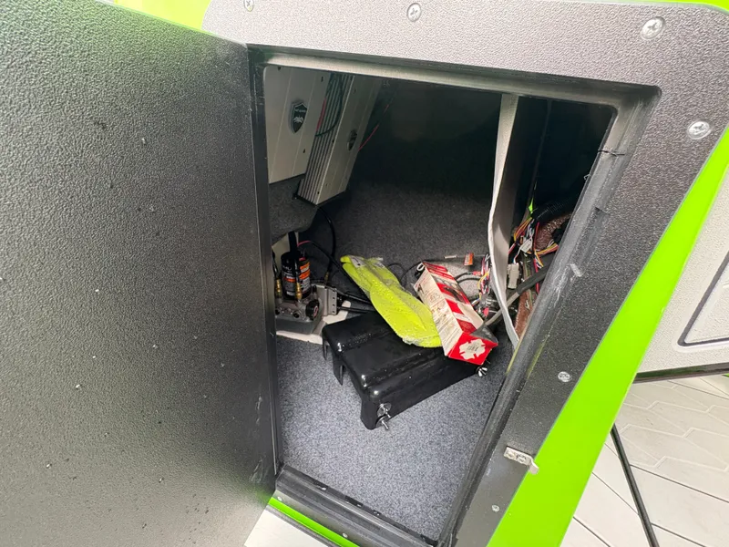 Slide: The Image of Storage compartment of 2022 Yamaha Boats 255XD, showing equipment and wiring. - 28