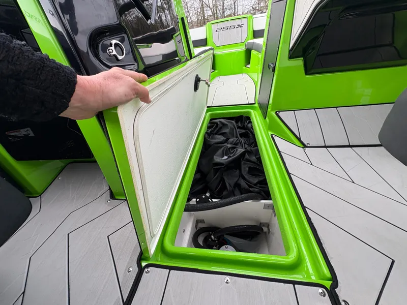 Slide: The Image of 2022 Yamaha Boats 255XD storage compartment with green accents and sleek design. - 29