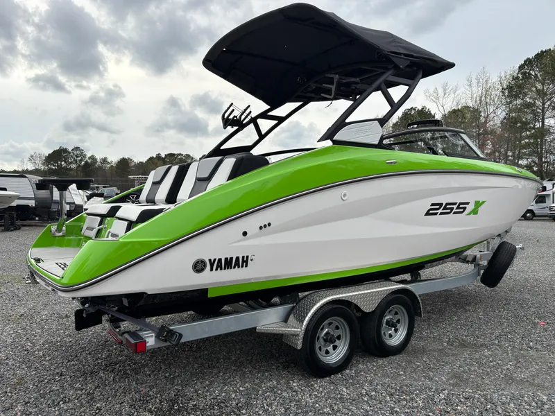 Slide: The Image of 2022 Yamaha Boats 255XD in vibrant green and white on a trailer, parked outdoors. - 5