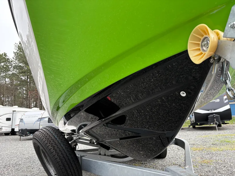 Slide: The Image of 2022 Yamaha Boats 255XD with vibrant green hull on a trailer, parked outdoors. - 8