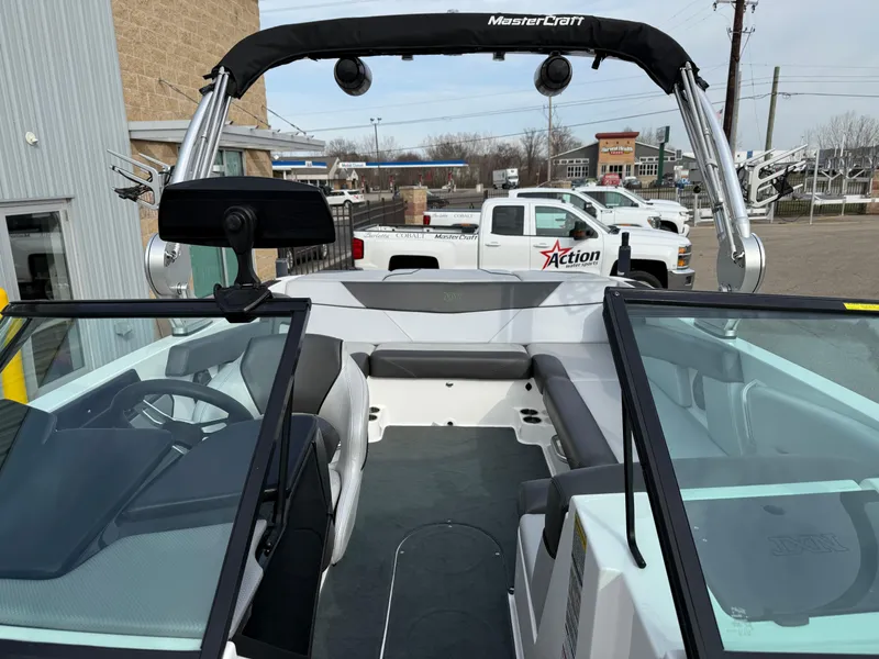 Slide: The Image of 2019 MasterCraft NXT22 boat interior with seating and steering wheel, parked near dealership. - 15