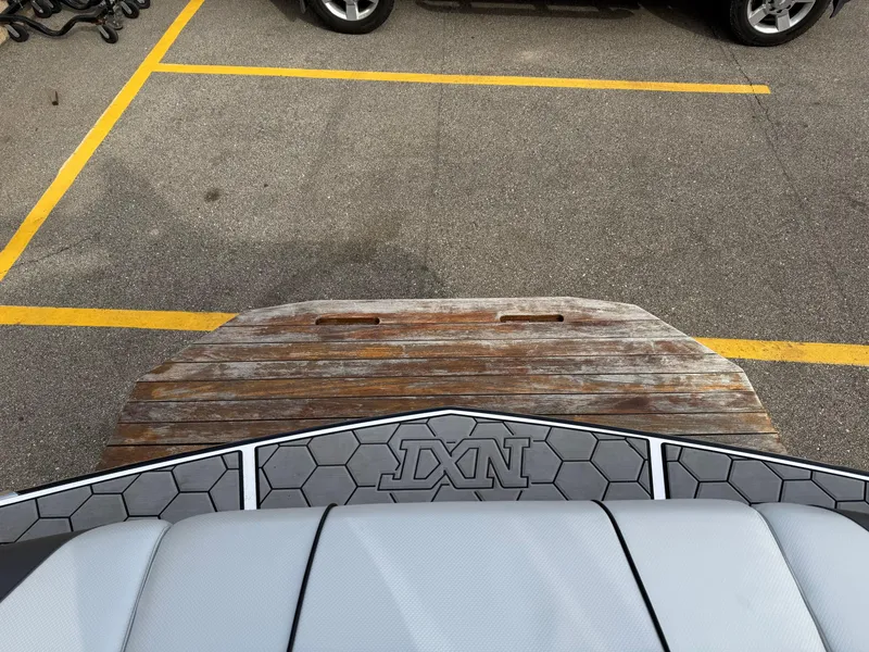 Slide: The Image of 2019 MasterCraft NXT22 boat with hexagonal pattern deck in parking lot. - 20