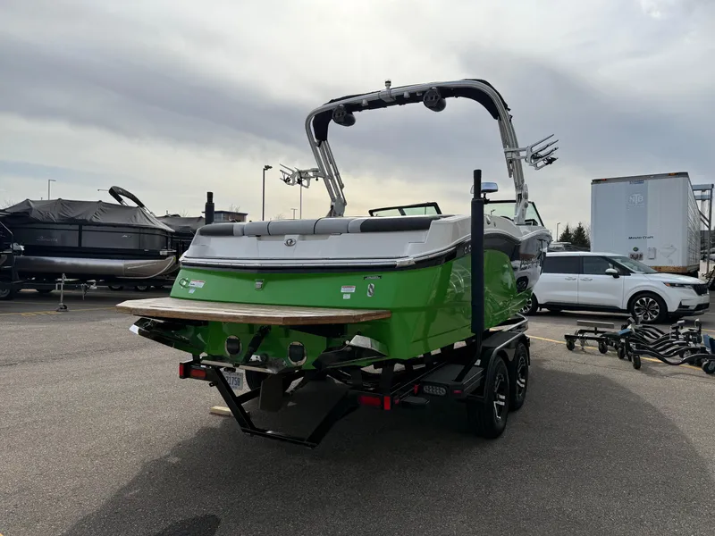 Slide: The Image of 2019 MasterCraft NXT22 boat in vibrant green on a trailer, parked outdoors. - 5