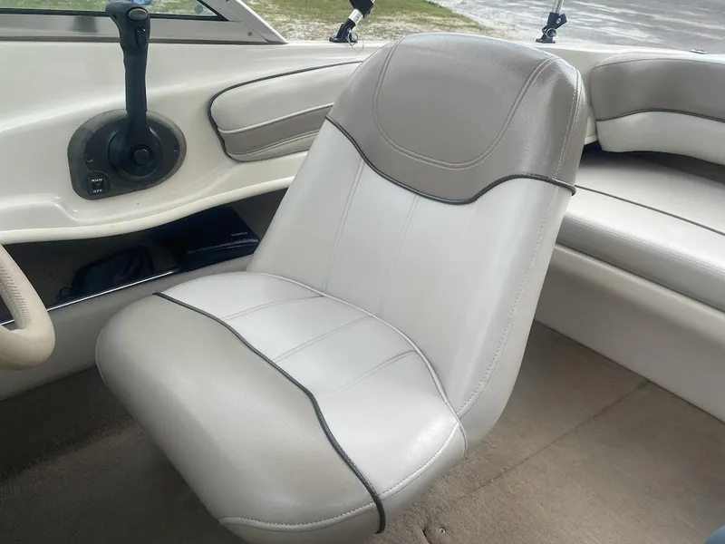 Slide: The Image of 2003 Sea Ray 182 SRX Bow Rider interior with beige seating and control panel. - 12