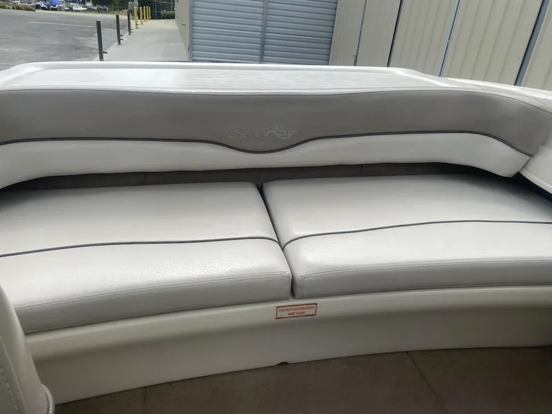 Slide: The Image of 2003 Sea Ray 182 SRX Bow Rider interior seating, white upholstery, outdoor setting. - 14