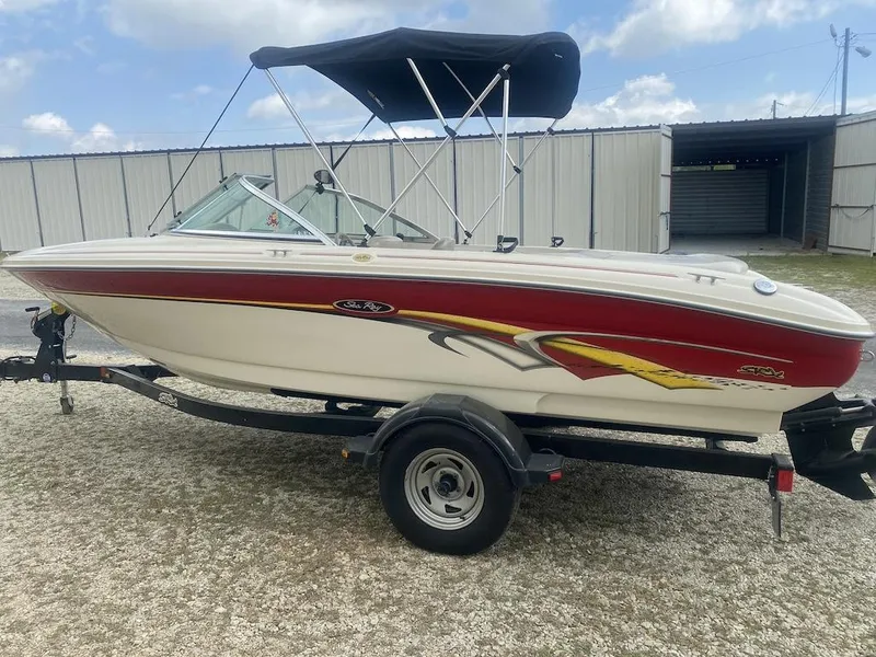 Slide: The Image of 2003 Sea Ray 182 SRX Bow Rider boat with red and yellow accents on a trailer. - 3