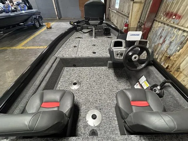 Slide: The Image of 2025 Tracker PT175TF boat interior with steering wheel, seats, and navigation equipment in a garage. - 4