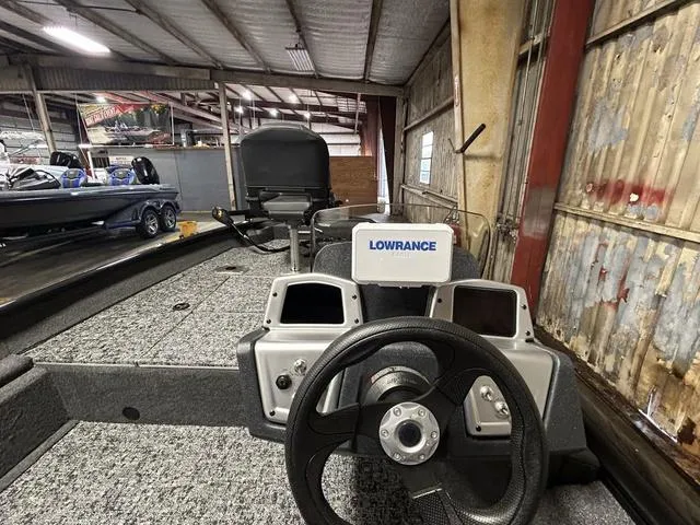 Slide: The Image of 2025 Tracker PT175TF boat interior with Lowrance navigation system in a warehouse setting. - 5