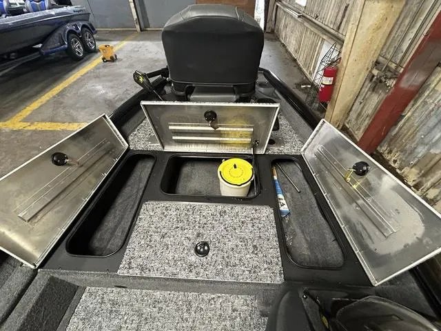 Slide: The Image of 2025 Tracker PT175TF boat interior with open storage compartments in a garage setting. - 8