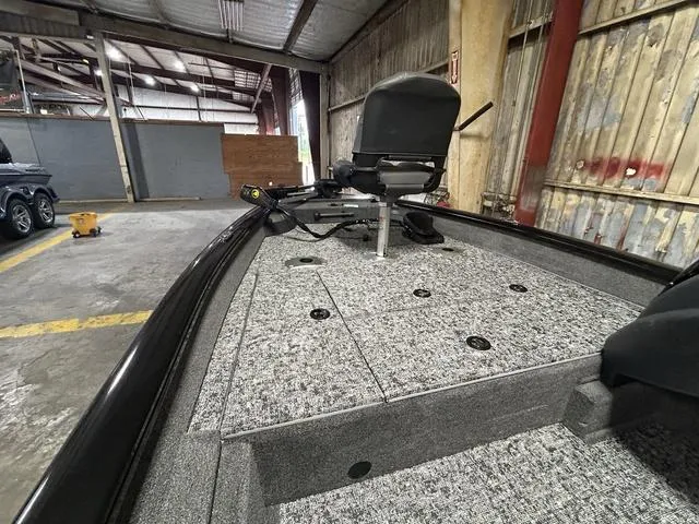 Slide: The Image of 2025 Tracker PT175TF boat interior with seating and storage in a warehouse setting. - 9