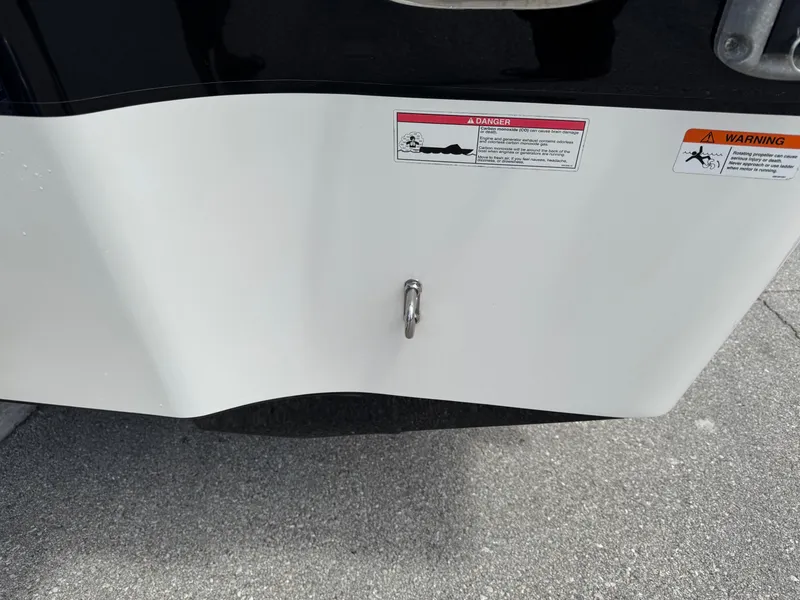 Slide: The Image of 2016 Wellcraft 241 boat stern with safety warning labels and metal hook. - 10